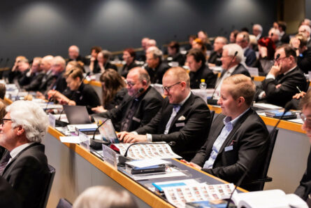 Ihmiset istuvat riveittäin auditoriossa.