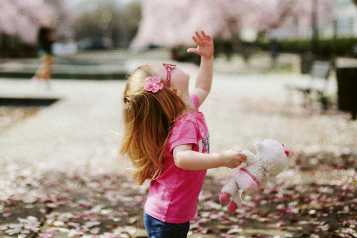 a_girl_standing_under_tree_holding_a_teddybear_photo_unsplash