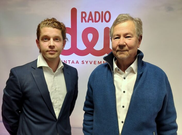 Heikki Vestman ja Esa Ylikoski seisovat Radio Dein logon edessä.